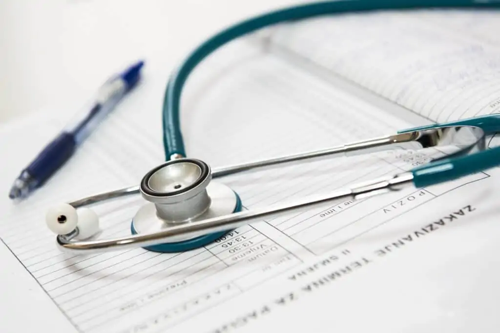 A stethoscope and blue pen in an open notebook